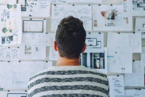 Man looking at a wall of paper
