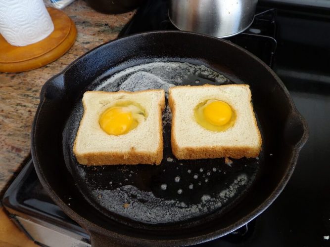 Cast iron skillet cooking egg on toast