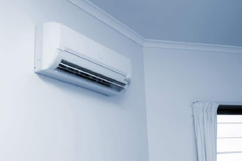 A typical wall air conditioner attached to a wall.