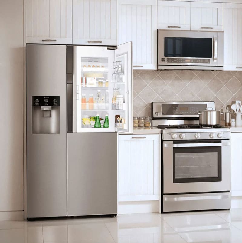 A microwave, oven and refrigerator in a kitchen