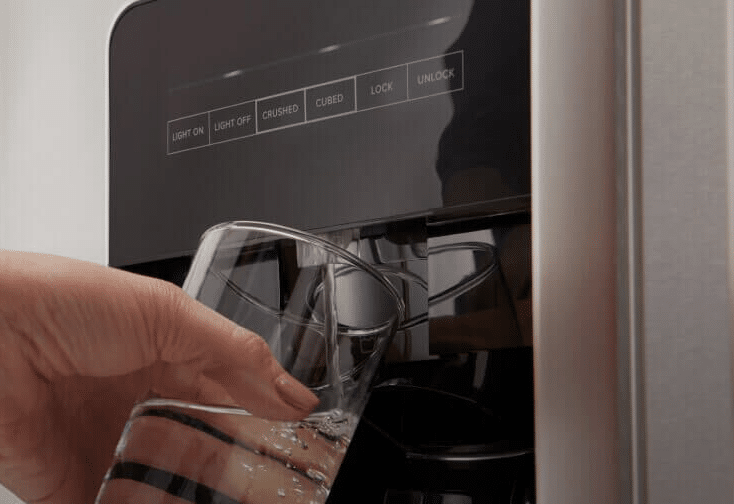 A person getting water from a refrigerator water filter