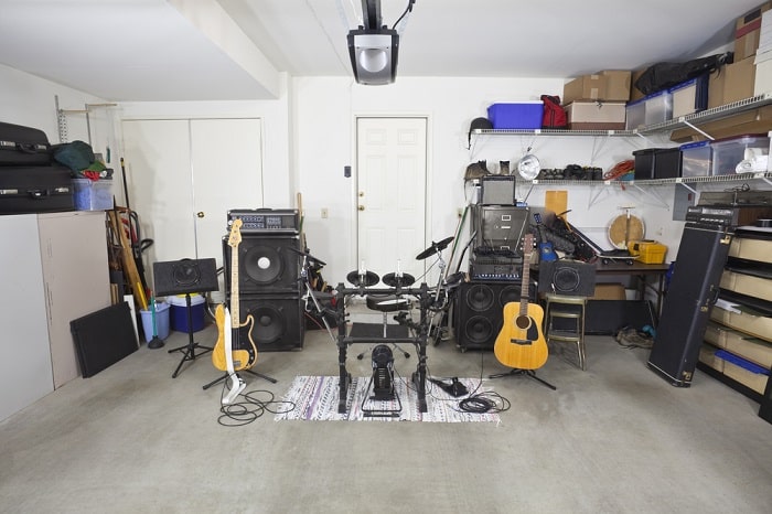 Rock band music equipment in a cluttered suburban garage.