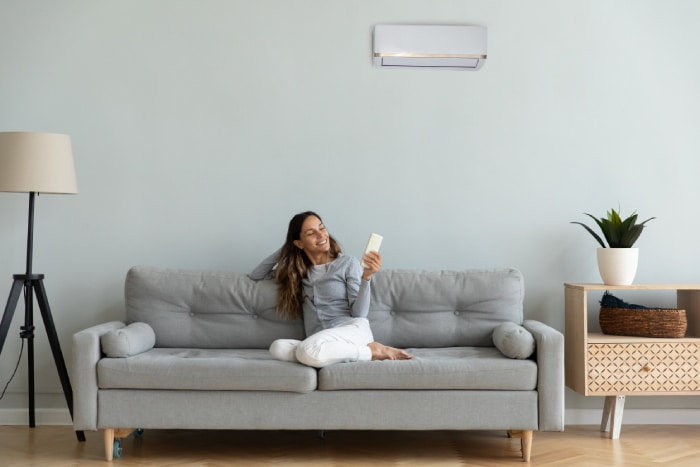 female holding an air conditioner remote