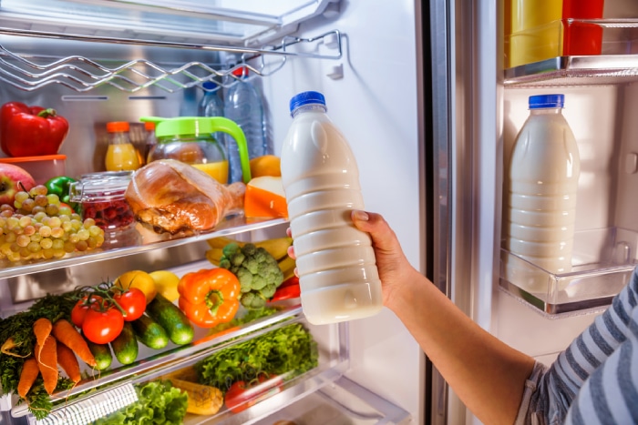 checking a bottle of milk from the refrigerator 