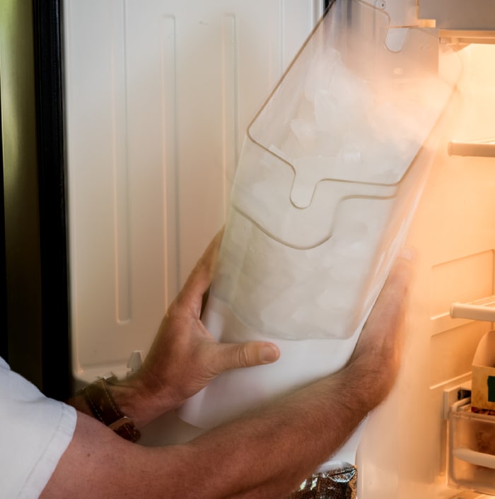 male removing ice maker tub