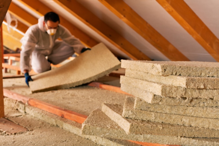 male installing insulation in the attic