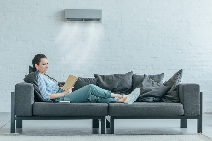 female relaxing on a couch with clear view of AC