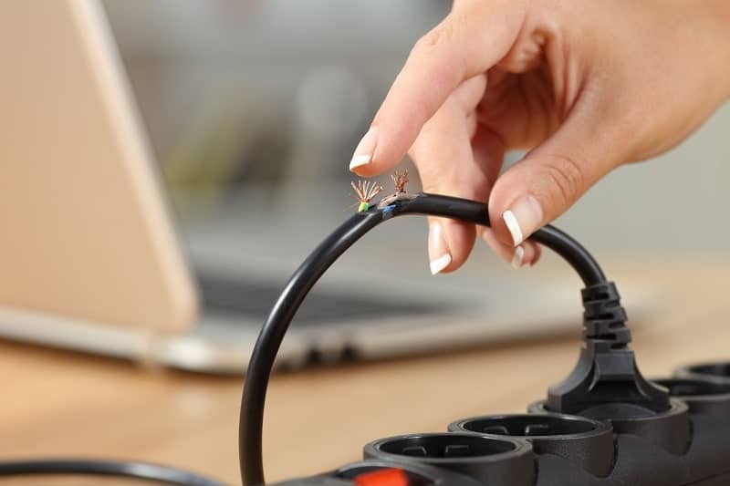 A woman touching a damaged electrical cord