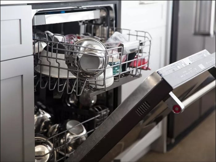 An open dishwasher loaded with dishes