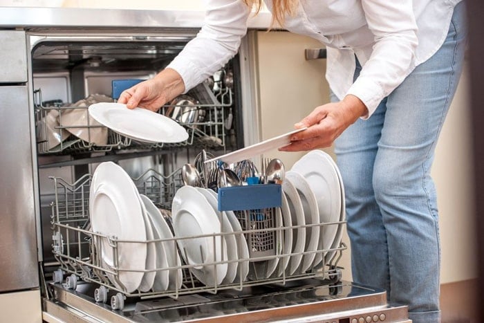 Woman using a dishwasher