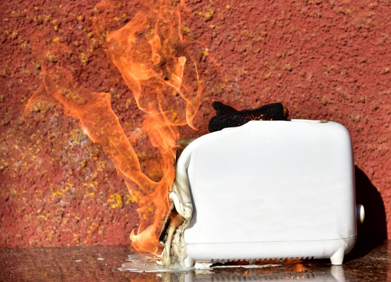 Burning toaster with bread inside.