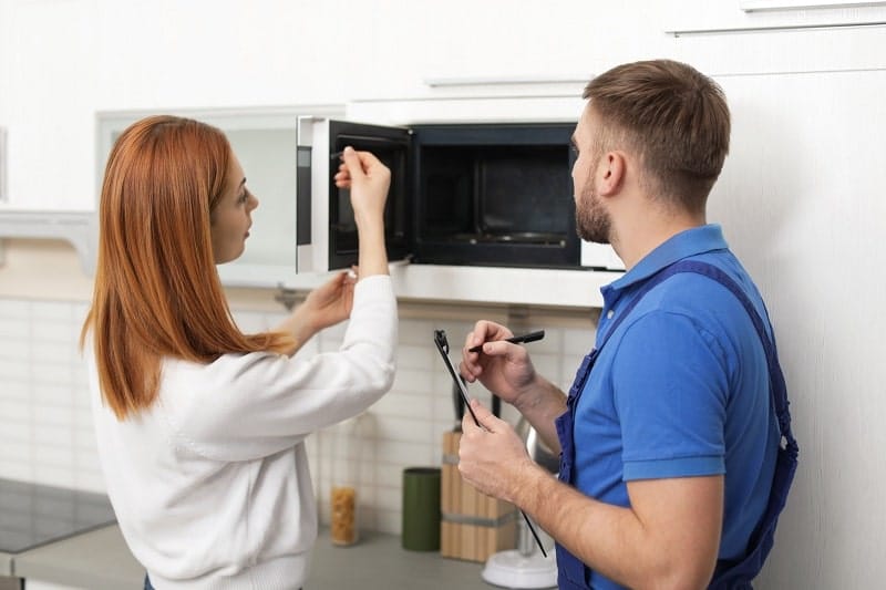 A girl checking her microwave door latch