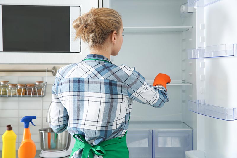 a woman cleaning the fridge