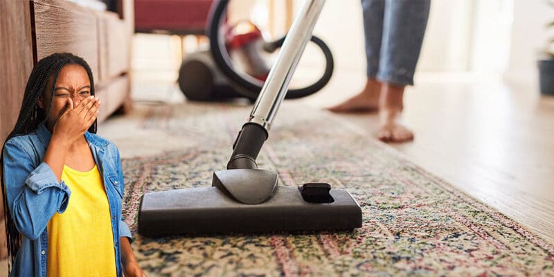 A person cleaning the carpet with a vacuum