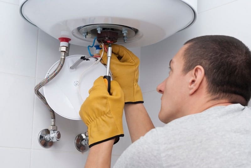 A man checking the inside of a water heater