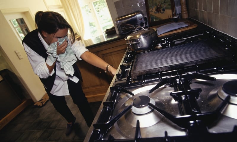 Woman using a tablecloth to avoid the gas smell