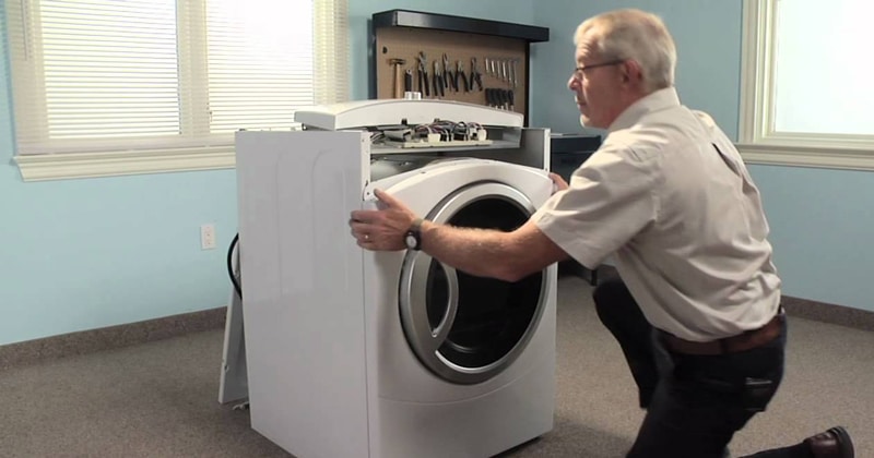 Man taking out the front panel of a dryer