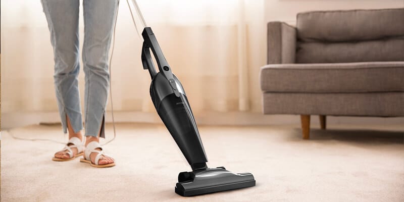 Woman using a vacuum to clean the carpet