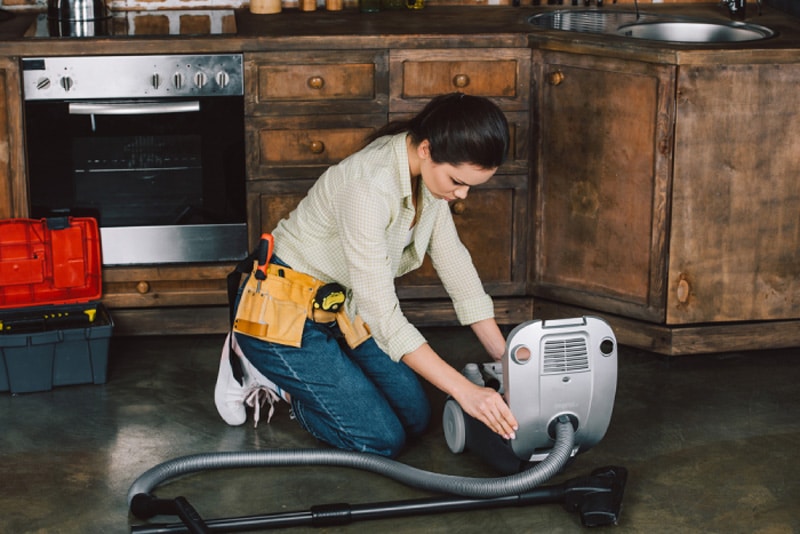 Woman Cleaning Vacuum Filter