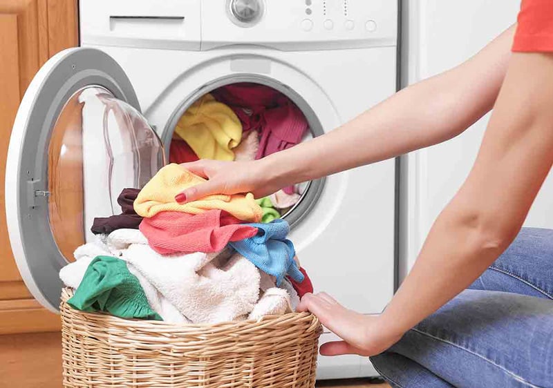 Woman Taking Out Clothes From Dryer