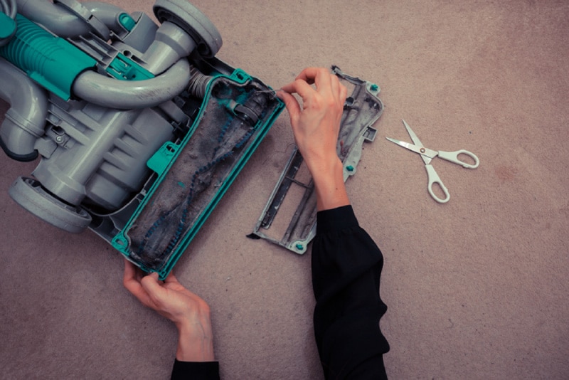 Female hands checking inside of vacuum seaching for obstructions