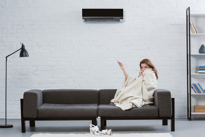 woman wrapped in blanket in her living room