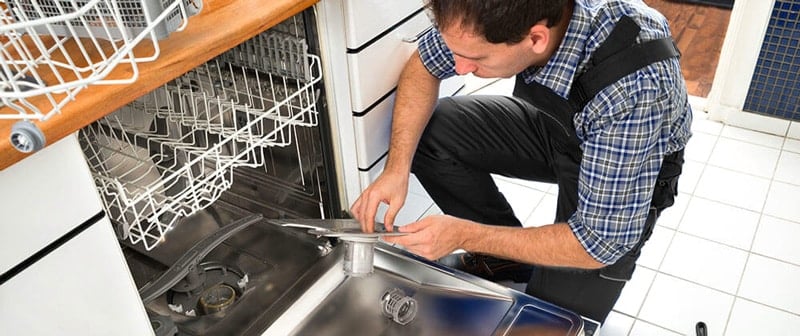 A man repairing a dishwasher motor