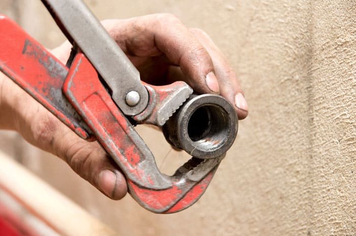 hand installing a pipe