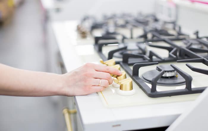 hand turning on the gas stove