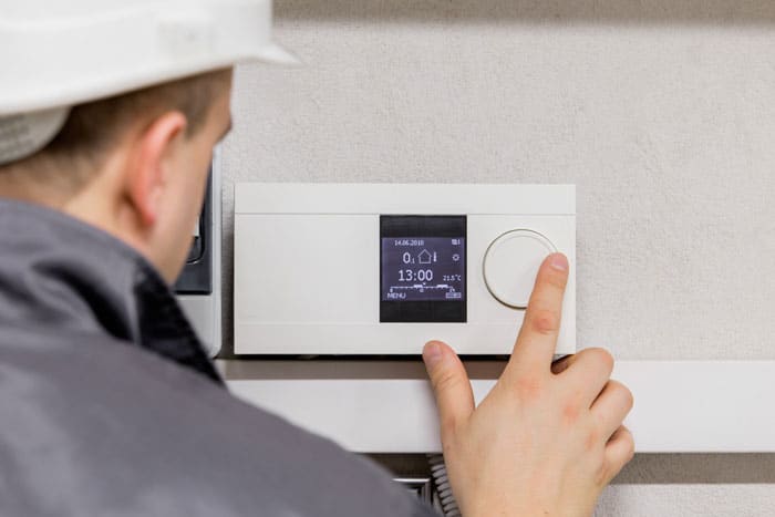 man checking thermostat