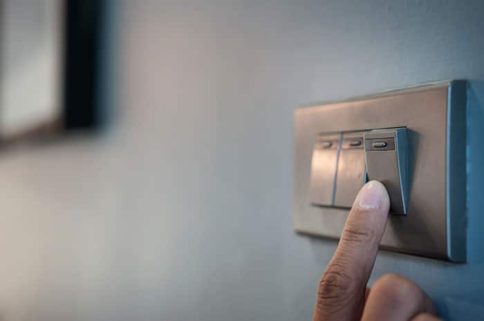 hand turning off light switch