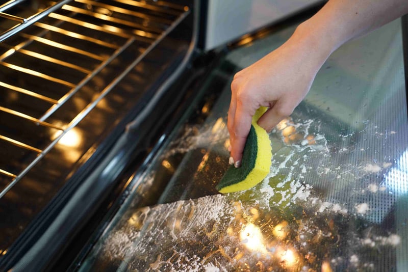 Hand cleaning oven door glass
