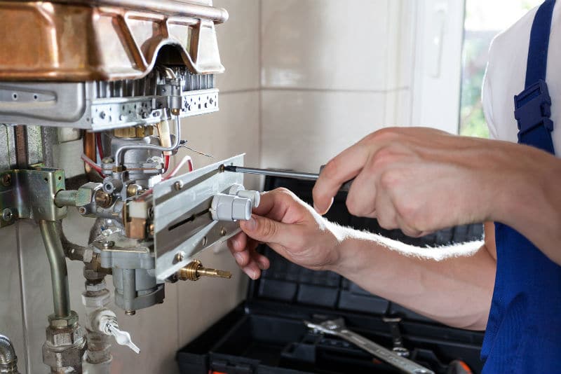 Man repairing gas water heater