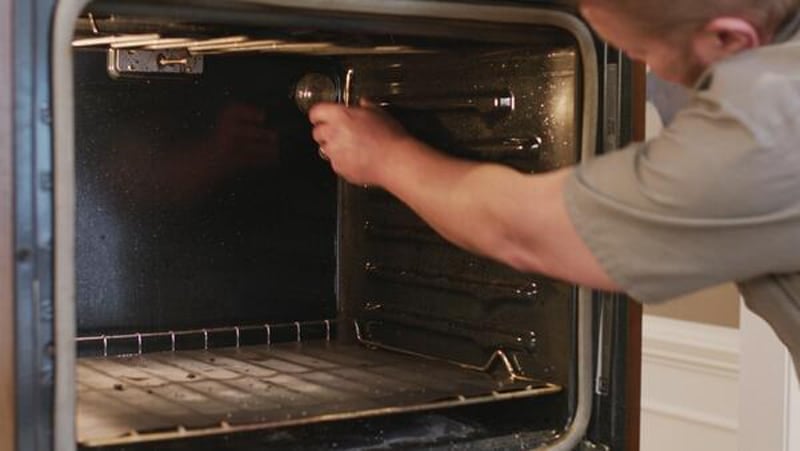 Man taking out oven light bulb