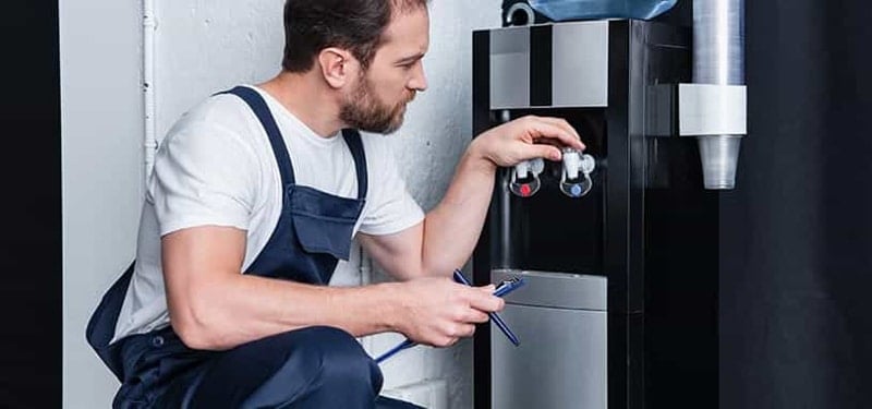 man inspectin damaged water cooler