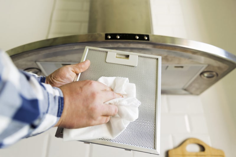 Man cleaning grease filter