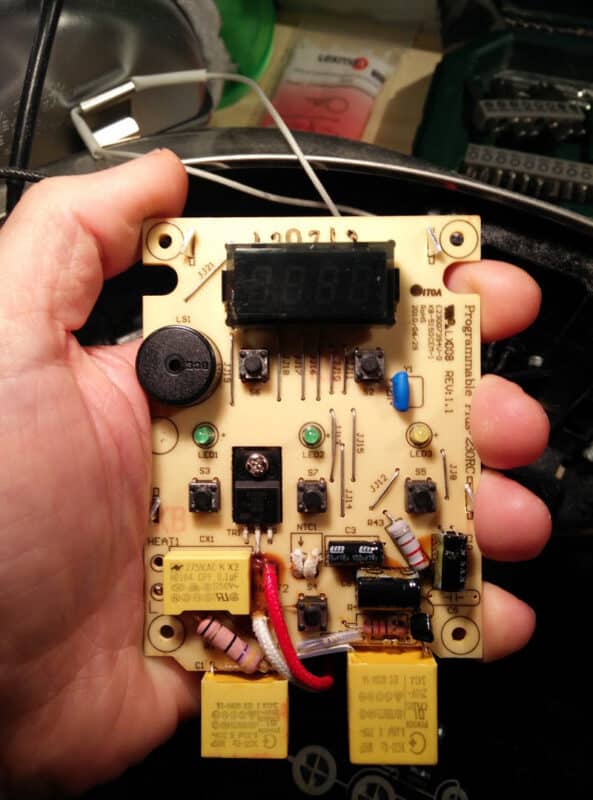 Hand holding slow cooker circuit board