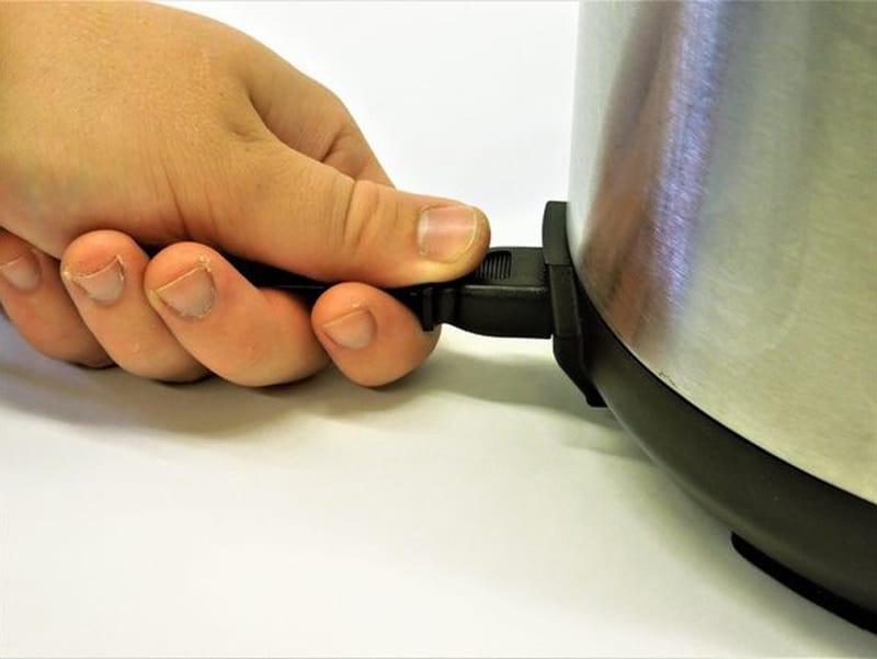 Hand conecting power cord to slow cooker