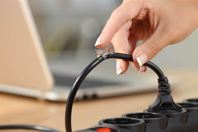 Hand almost touching damaged power wire