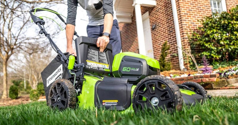 Taking out grass from fully loaded lawn mower