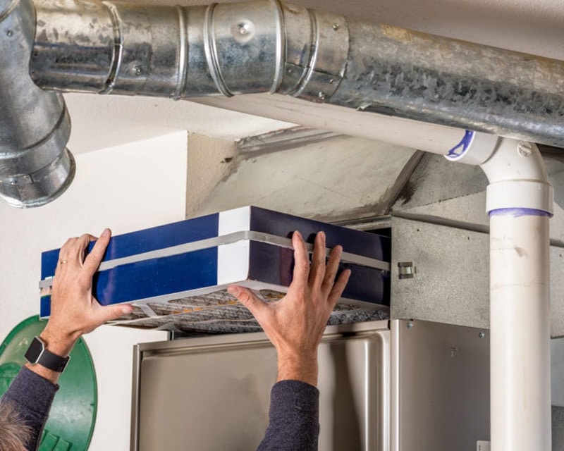 Man replacing furnace filter