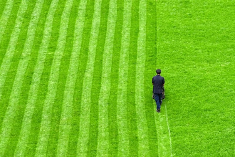 Man making pattenrs with grass