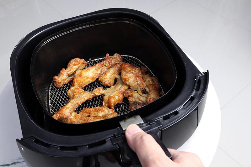 cooked meat in an air fryer basket