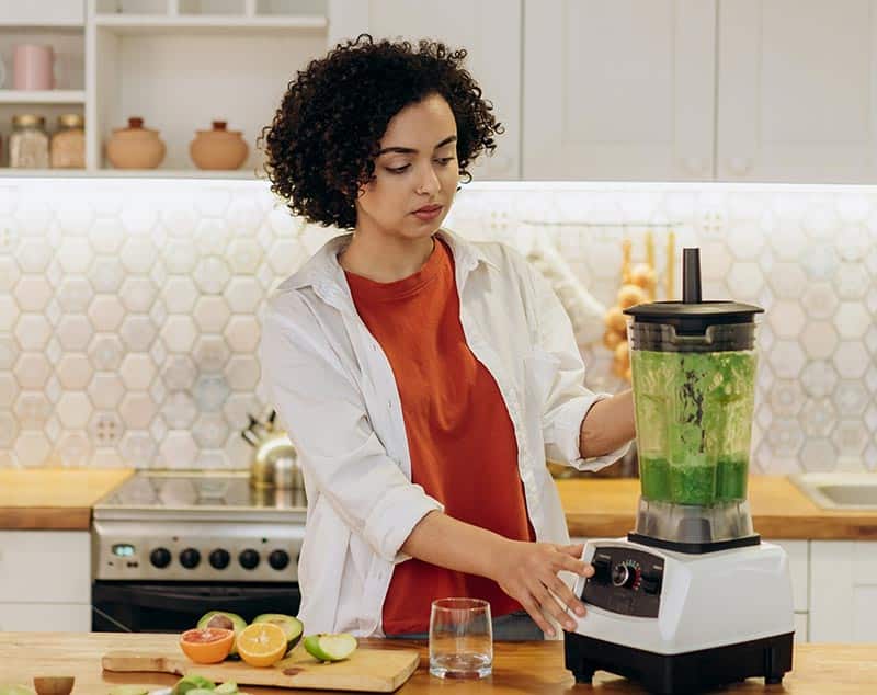 a woman blending fruits