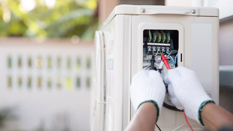 Hands Measuring Conductivity Of AC