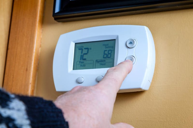 Hand Triying To Set Temperature From Thermostat