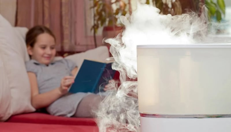 Girl Reading Next To Humidifier