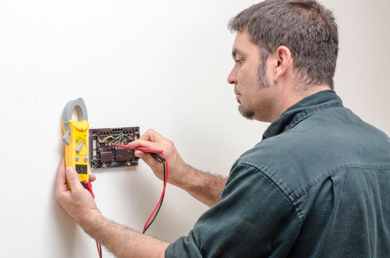 Man Using Multimeter To Measure The Thermostat Conductivity