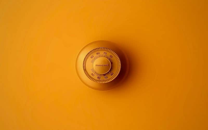 Orange Electric wall heater thermostat on the wall