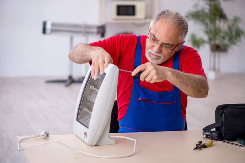 professional technician repairing heater